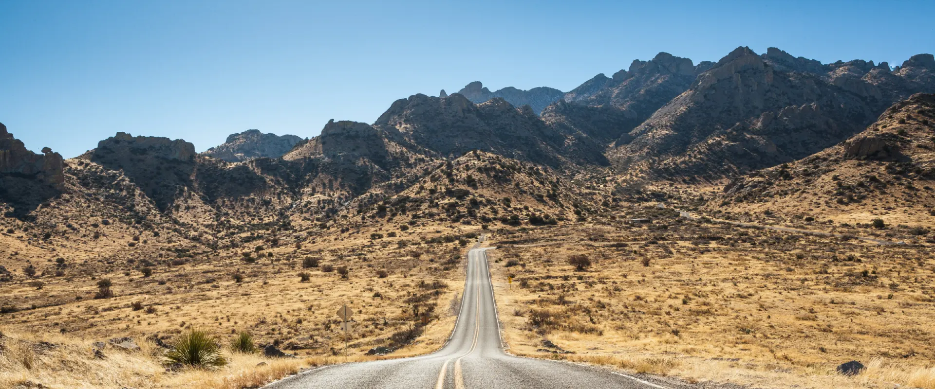 Rural desert road leading into the mountains near Deming, New Mexico